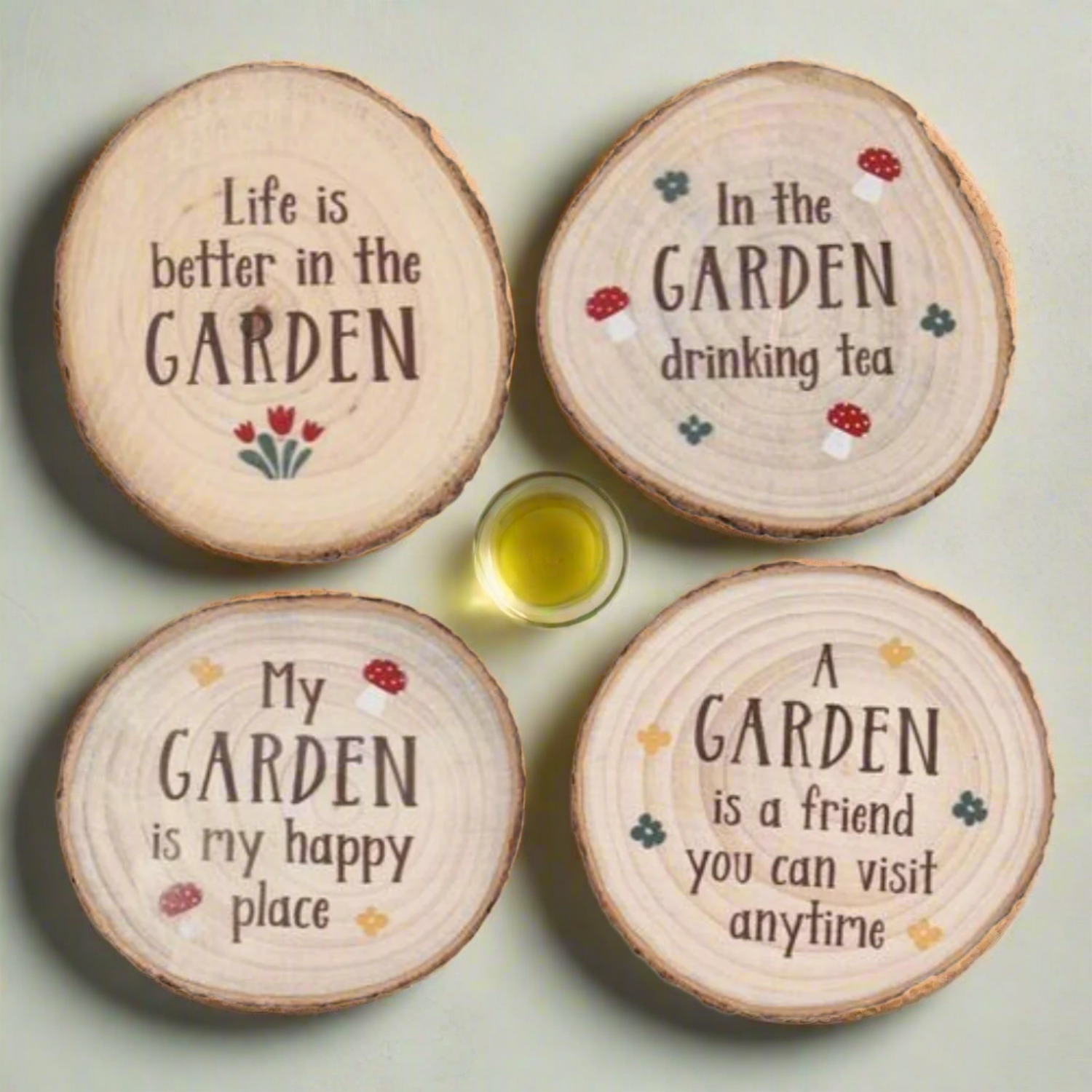 Four wooden coasters with garden-themed sayings on a white background