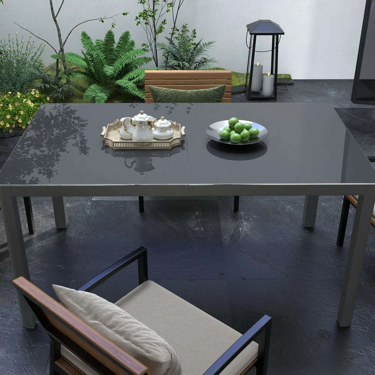 Grey glass-top aluminium table on patio with chairs and small tableware