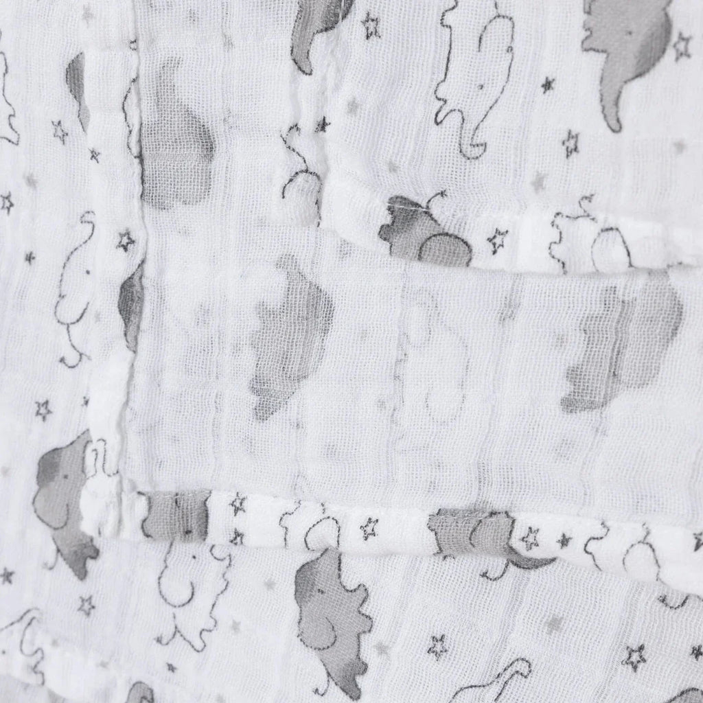 White muslin blanket folds with gray elephant print and subtle star pattern