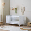 White mini cot bed with vertical slats and low side panels