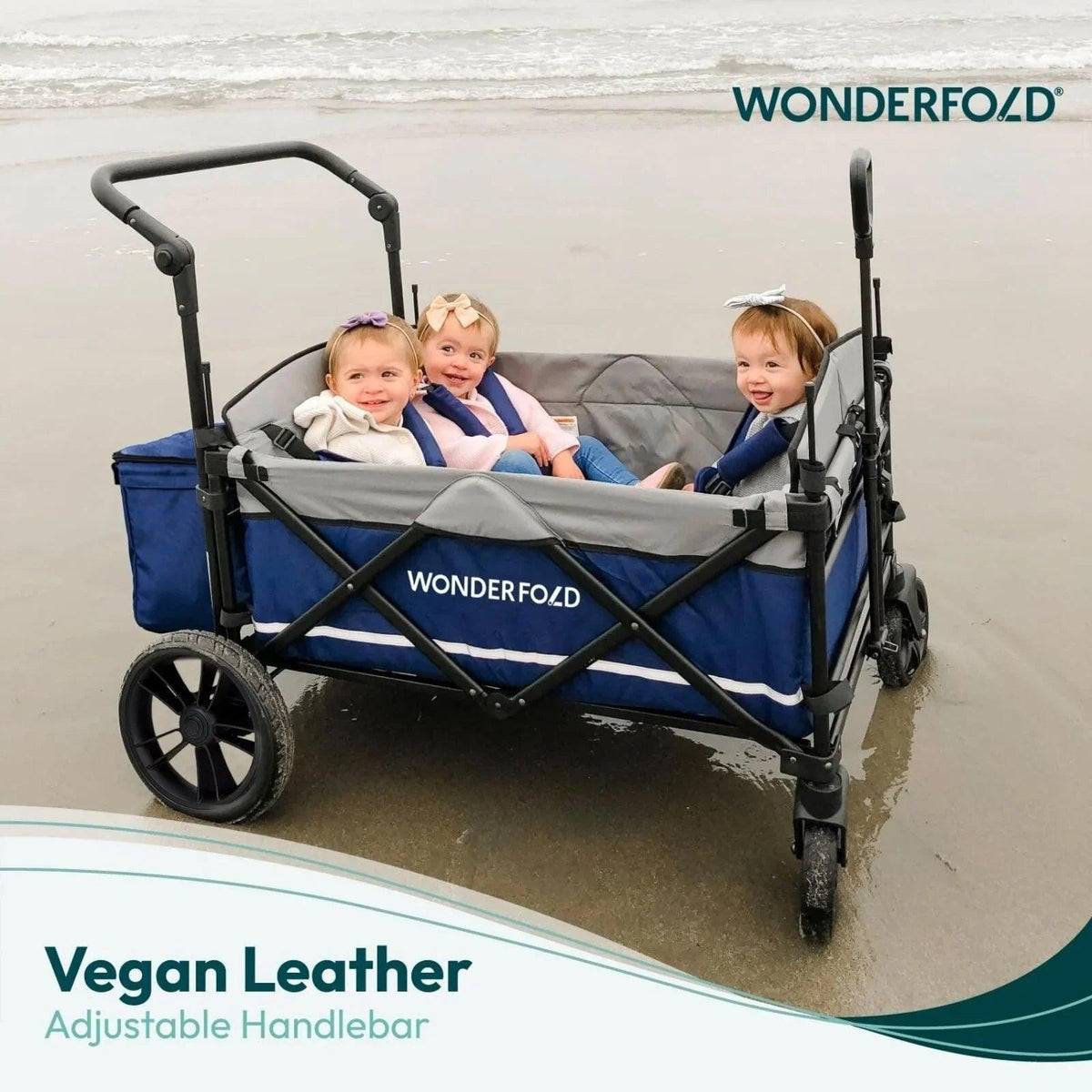 Black quad stroller wagon with Wonderfold logo and blue upholstery, at-beach scene