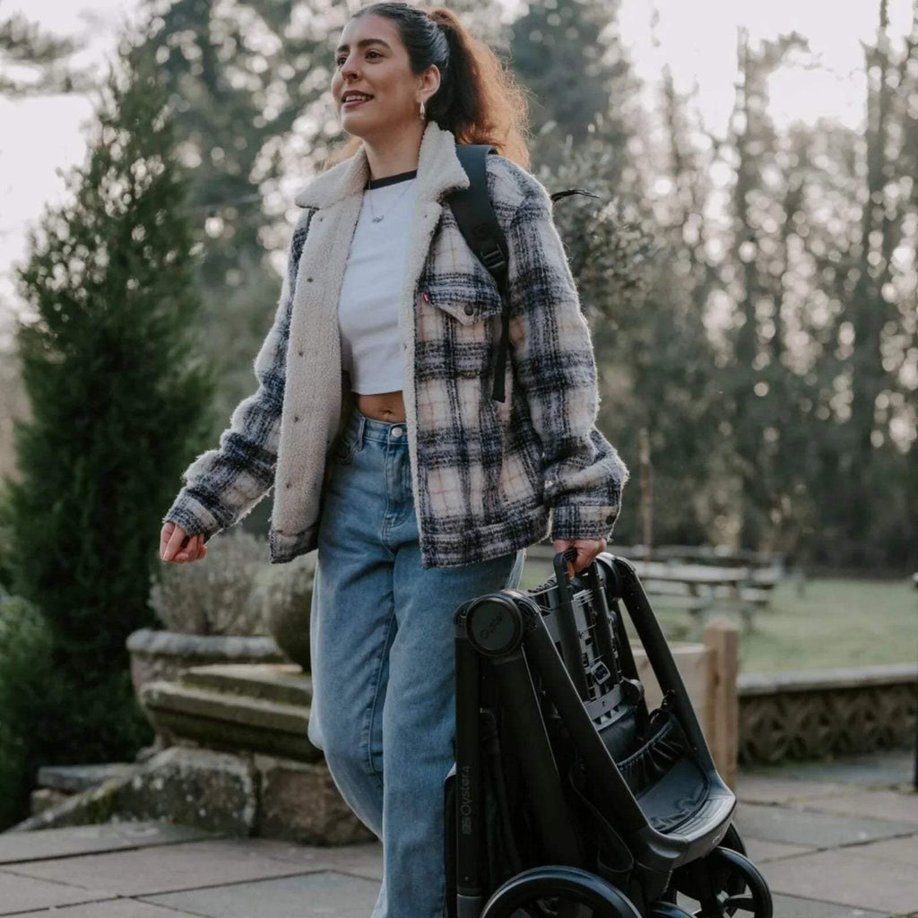 Black and buttermilk stroller with seat and canopy, carried bag hanging from handle