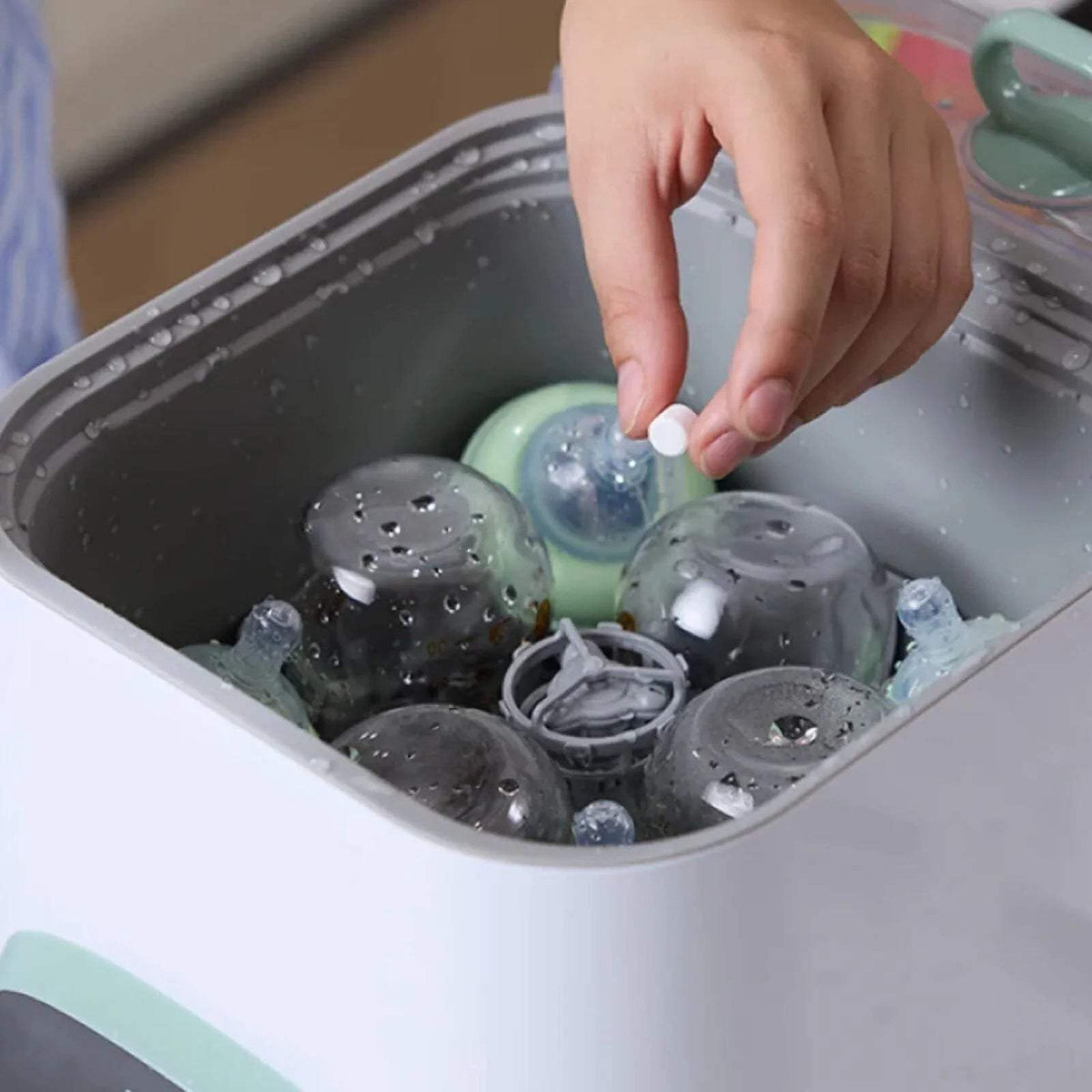 Baby bottle washer sterilizer dryer with bottle parts in open white basket, mint accents