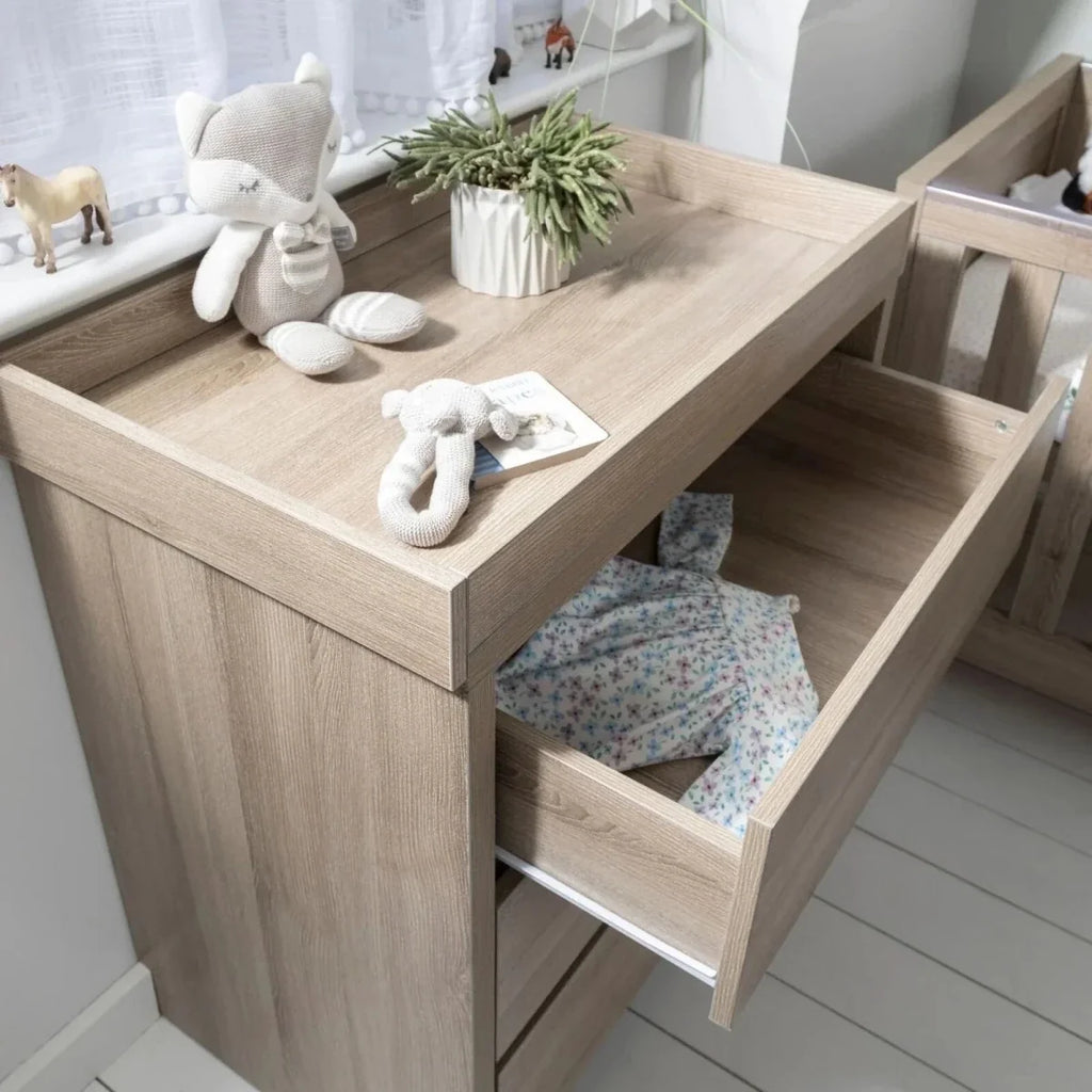 Oak changing unit with open changing top and built-in side shelf for essentials.