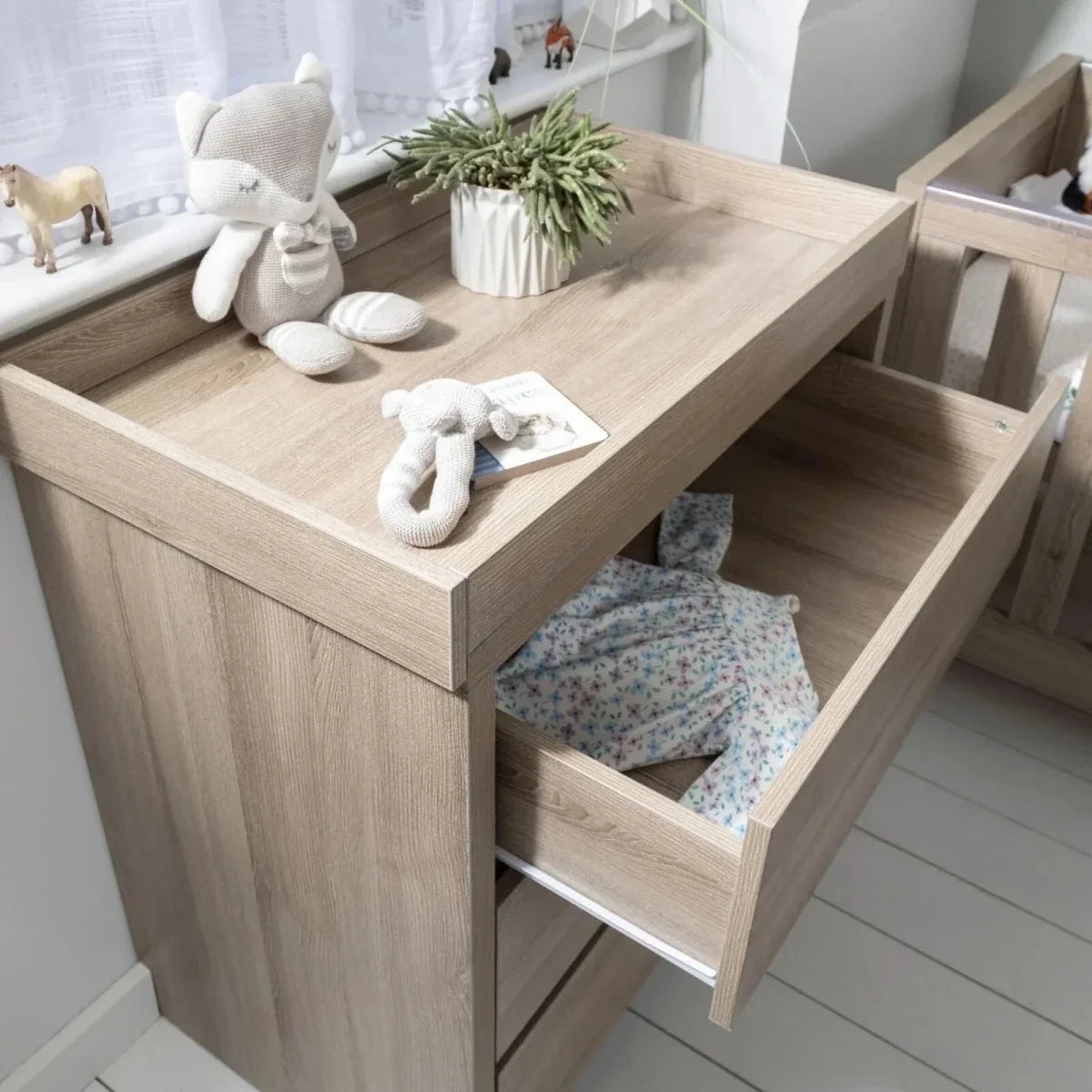 Oak changing unit with open changing top and built-in side shelf for essentials.