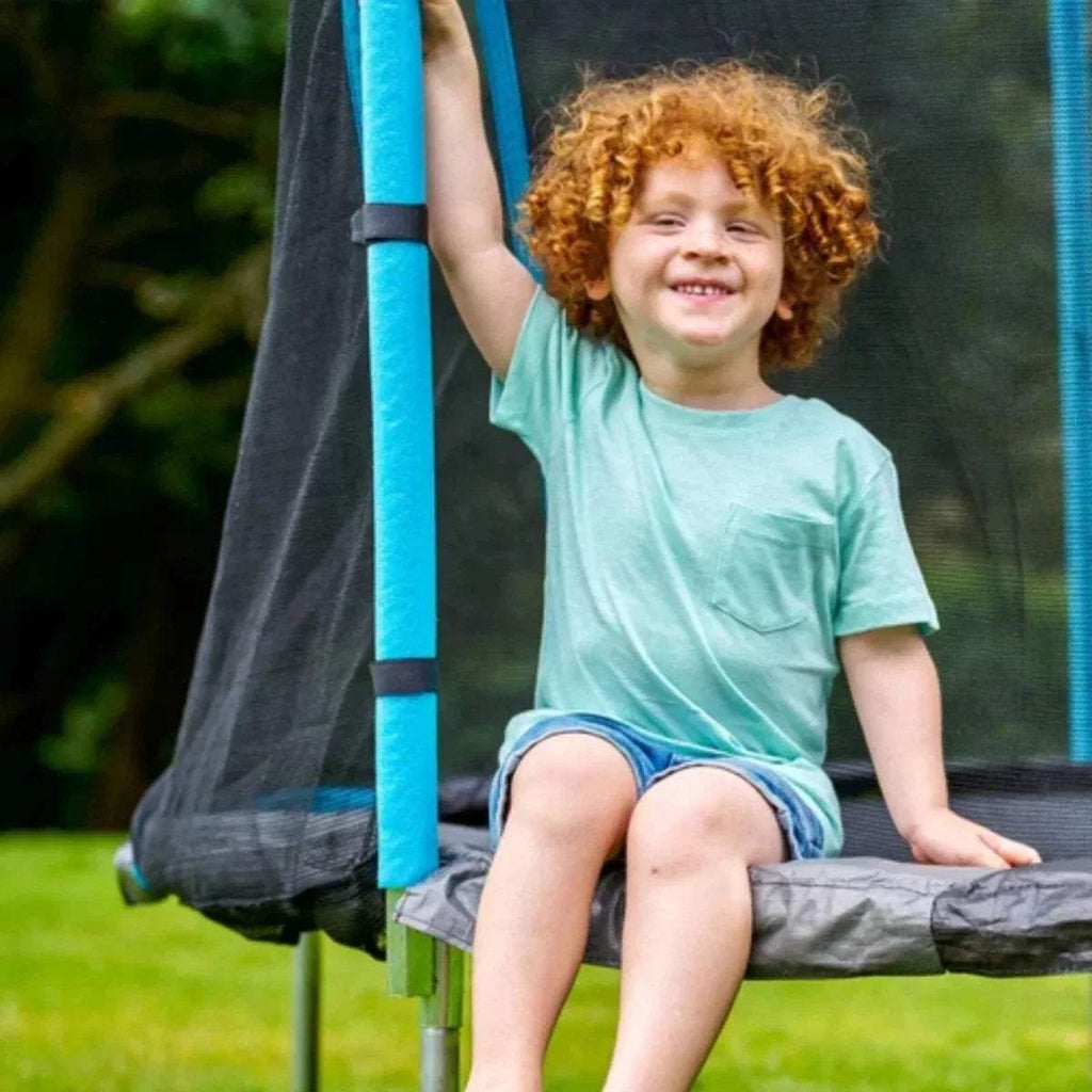 Trampoline jumping mat with blue support pole and black safety net, round frame