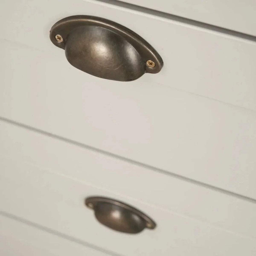 White chest drawer fronts with bronze curved metal handle pulls