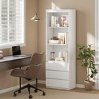 White bookcase with open cubby shelves and three front drawers, in an office setting.