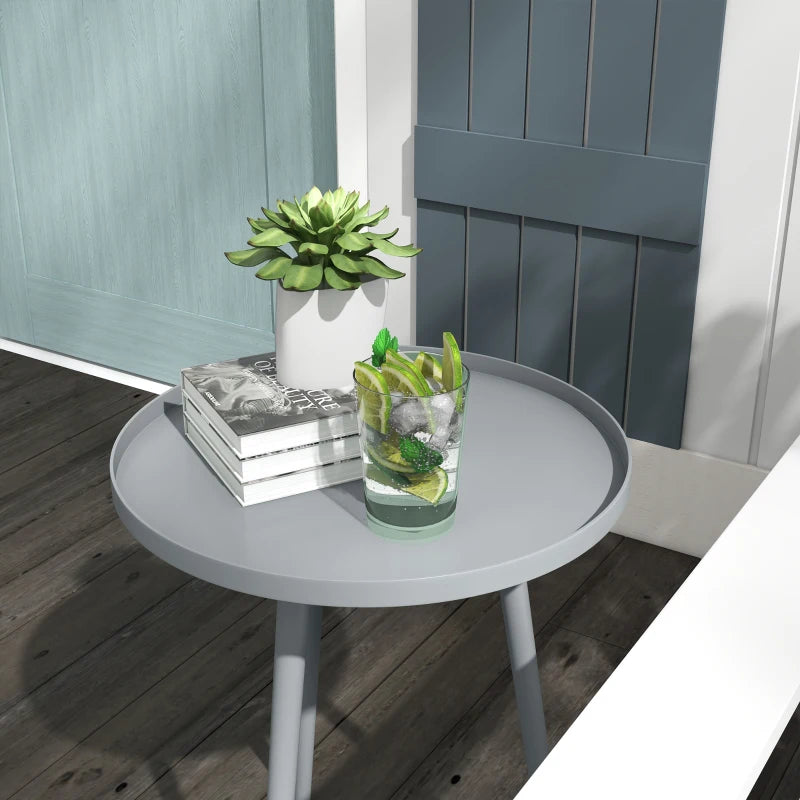 Grey round side table with flat circular top and four slender tapered steel legs