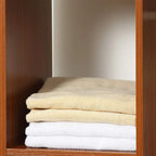Walnut storage wardrobe shelf with neatly folded light towels