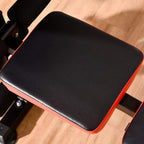 Padded bench seat cushion with black top and red edge trim on metal frame