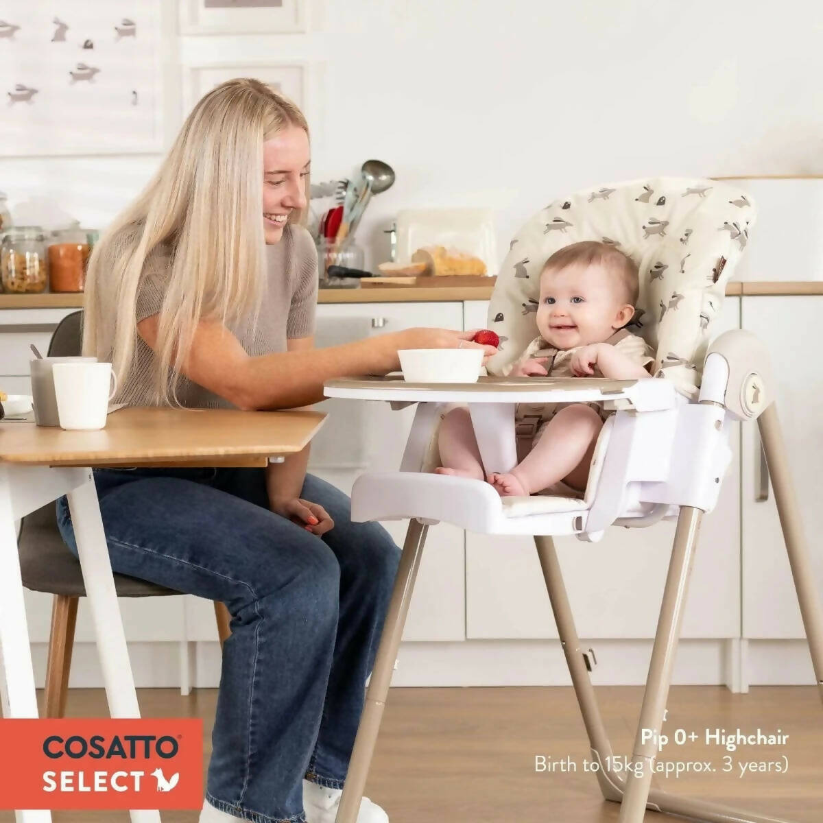 Cosatto Pip 0+ high chair with baby seated, car-pattern cushion and safety tray