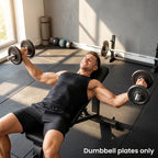 Grey metal dumbbell plates mounted on a gym bar, round discs with center holes
