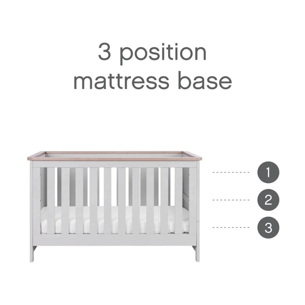 Cot bed with three mattress base height positions, white frame and oak-toned top rail