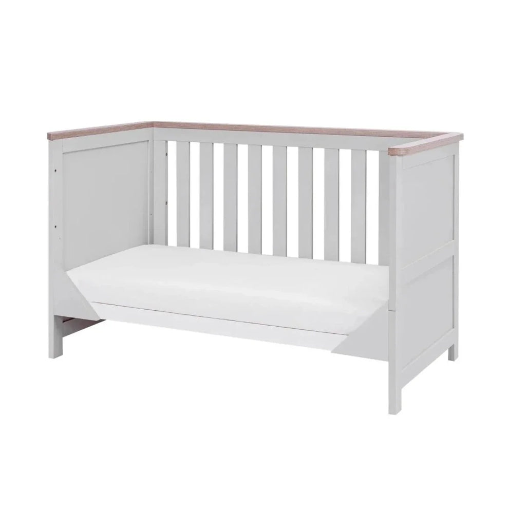 White and dove grey cot bed with vertical slats, oak-toned top rail, and fitted mattress