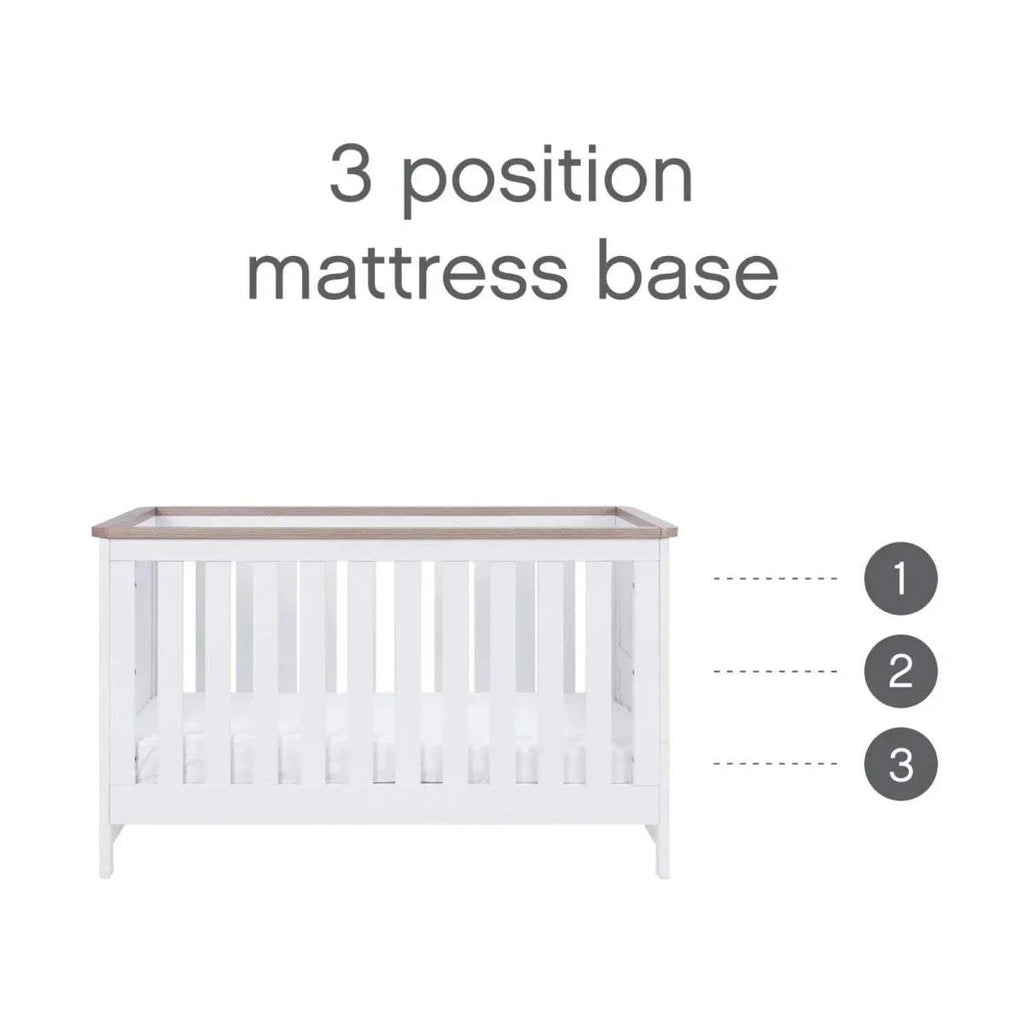 White cot bed frame showing mattress-base positions, with oak top trim
