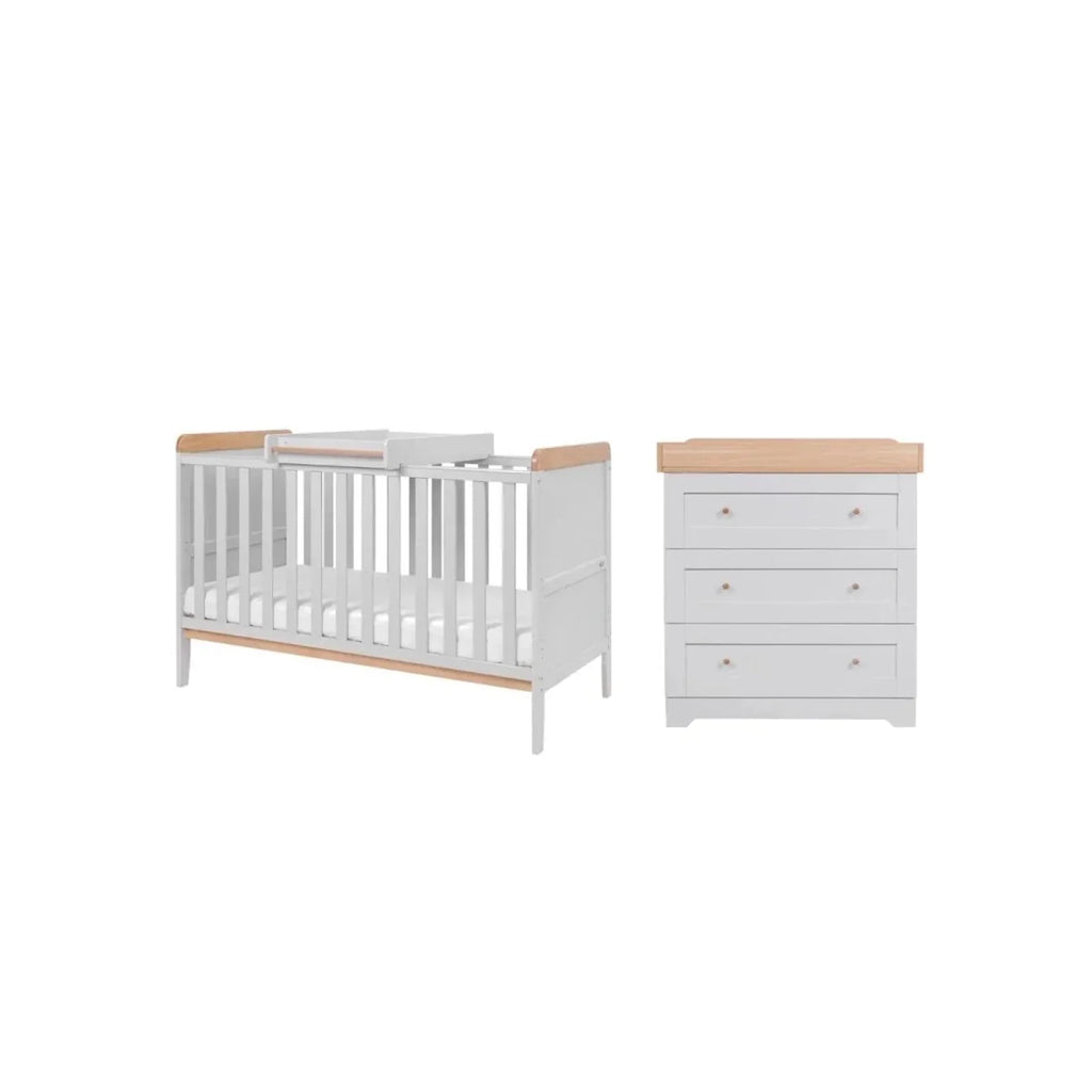 Dove grey cot bed with light wood rails and white dresser with drawers