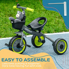 Kids black tricycle with front basket and lime wheels on outdoor path