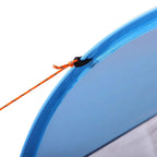 Blue tent edge with orange stake and fastening cord for secure setup