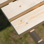 Close-up of slatted natural wood tabletop on a wooden picnic table bench