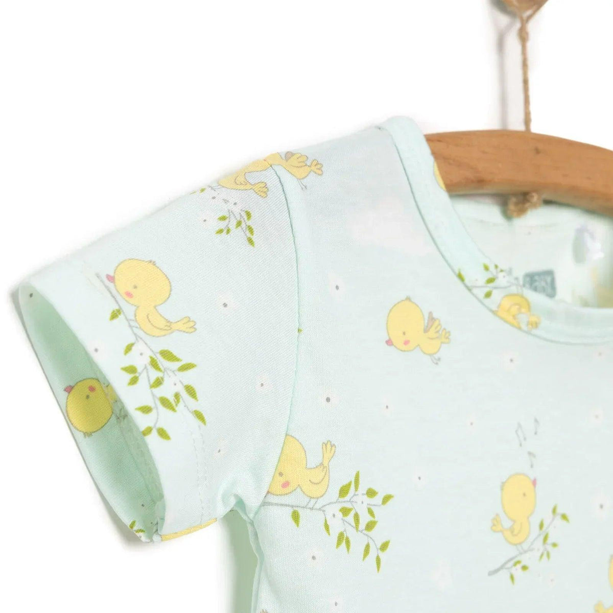 Light blue baby romper with yellow chick print and green sprigs, short sleeves and rounded neck