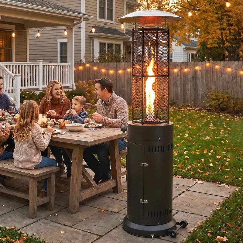 Black freestanding gas patio heater cylinder with glowing flame in outdoor patio area