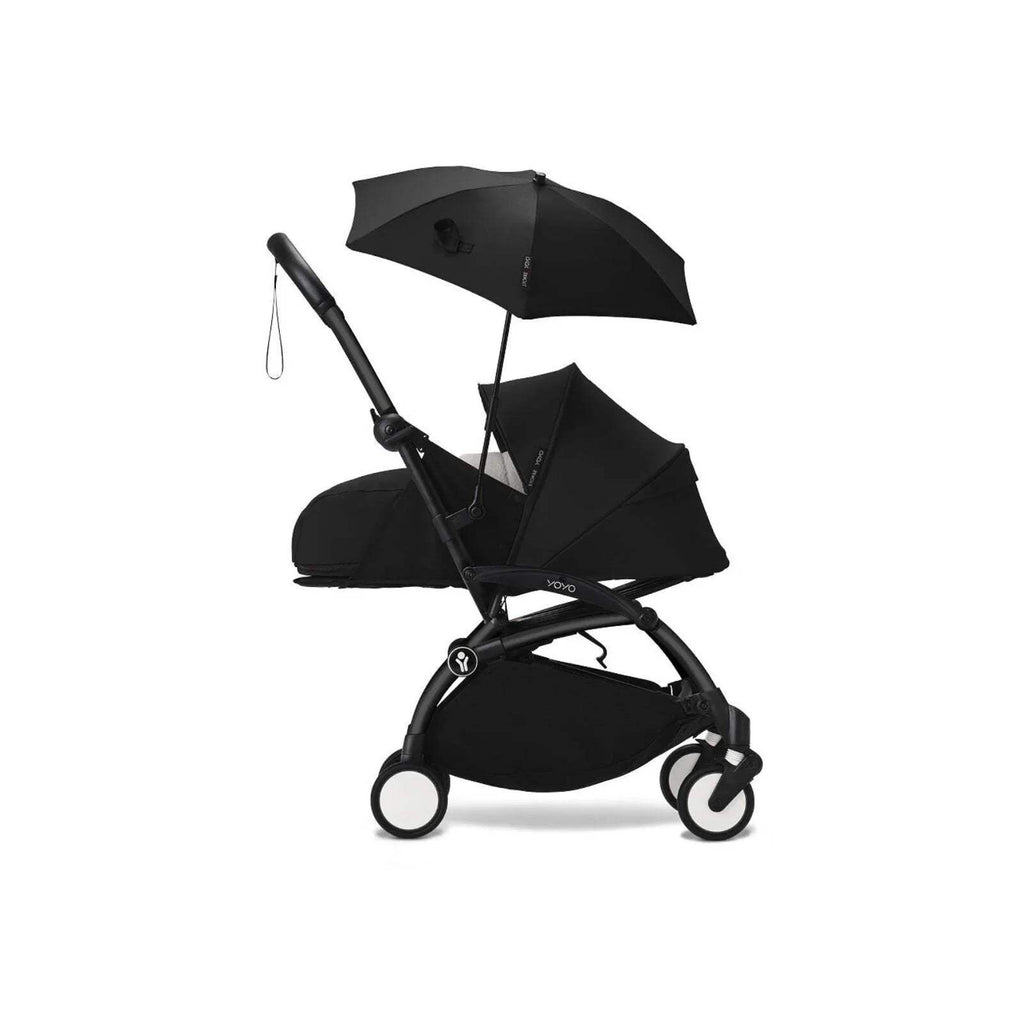 Black stroller parasol attached to pushchair, with open canopy and hanging strap
