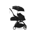 Black stroller parasol attached to pushchair, with open canopy and hanging strap
