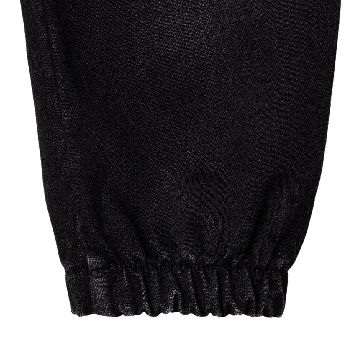 Black denim trousers close-up: elastic ankle cuff