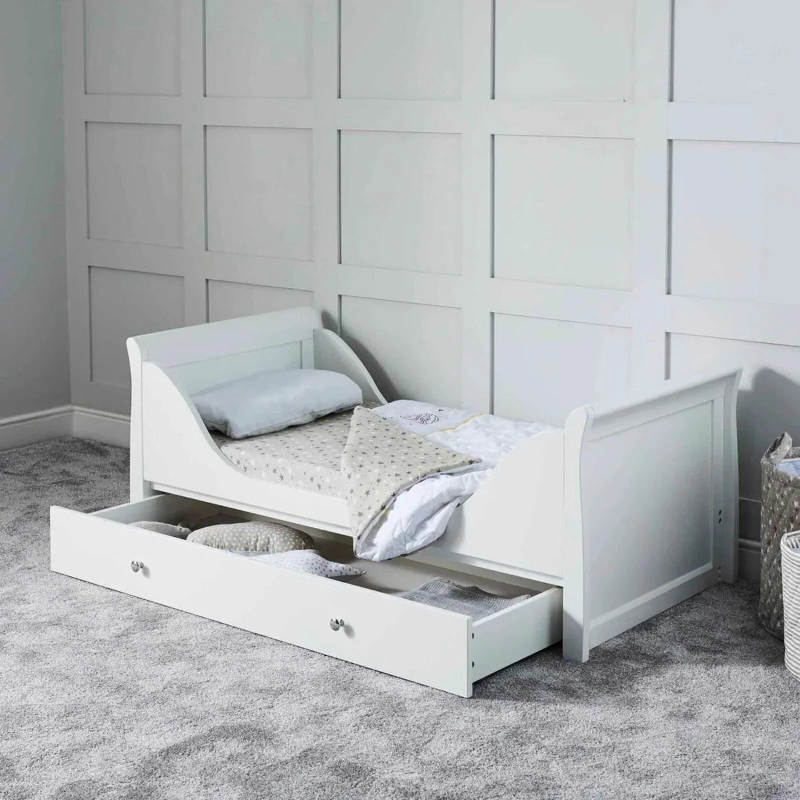 White cot bed with fibre mattress and bedding, open drawer storage front