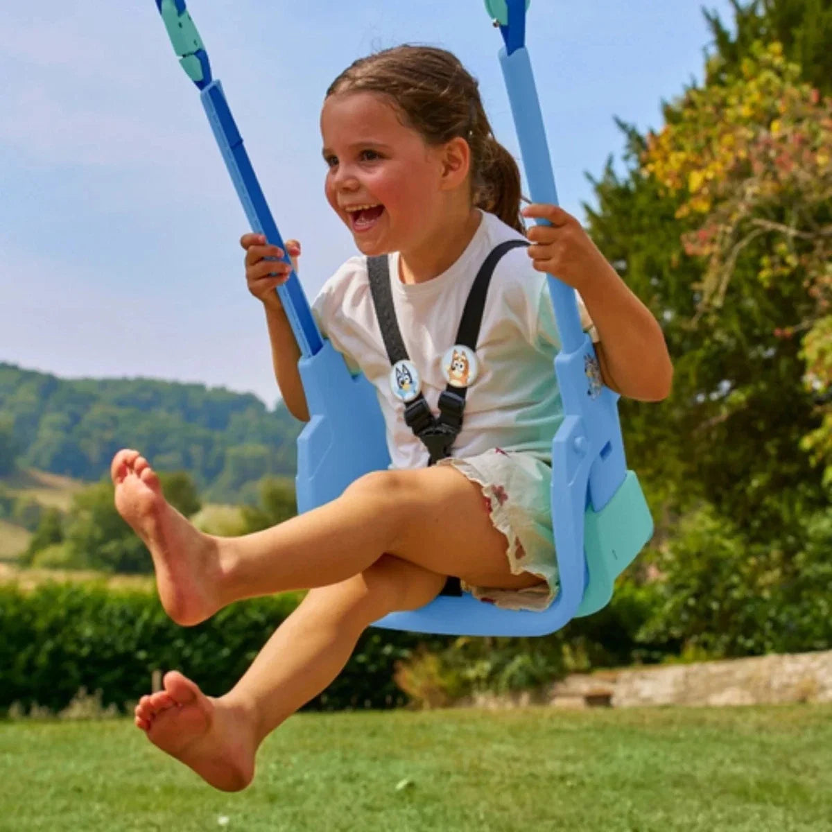 Blue outdoor swing seat with safety harness, toddler riding on the frame