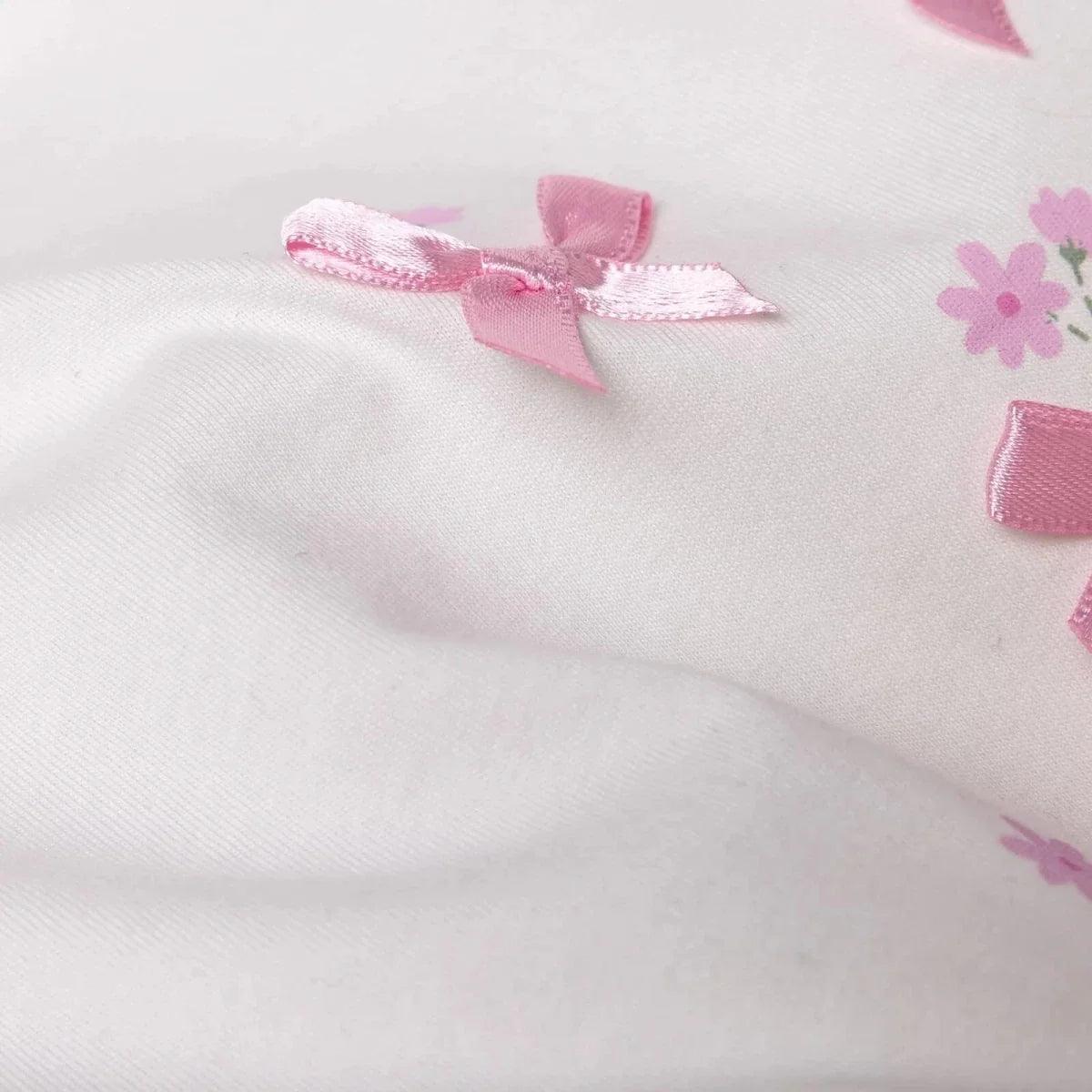 Ecru cotton blouse close-up with pink ribbon bow embroidery and small flowers