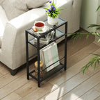 Black 3-tier side table with tempered glass shelves holding small items near a sofa.