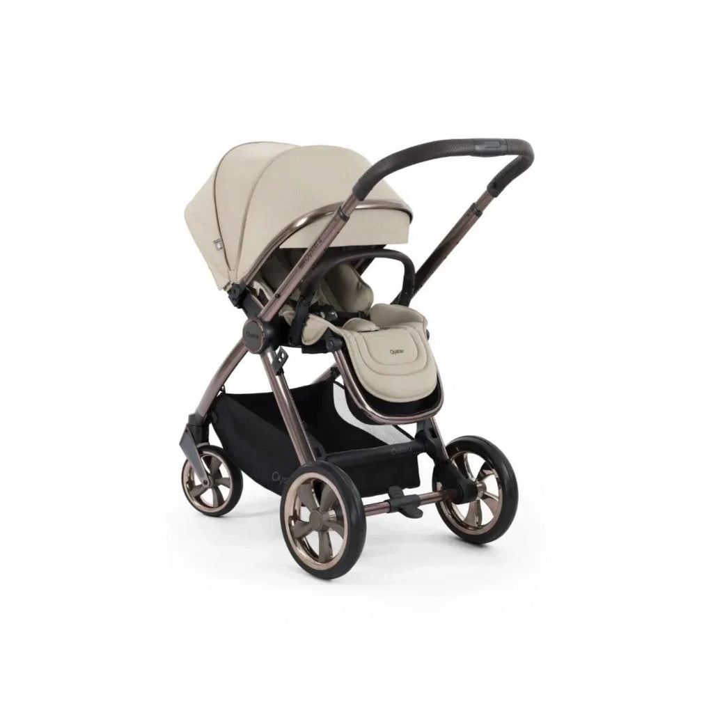 Single stroller in buttermilk with beige carry pocket and black seat, angled side view