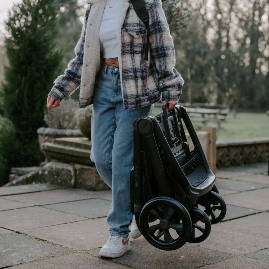 Single stroller with black seat and wheels, outdoors on a patio walkway