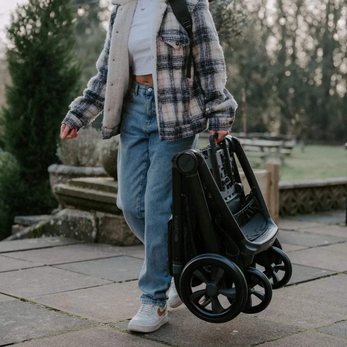 Carbonite single stroller with dark seat and wheels, shown in use outdoors