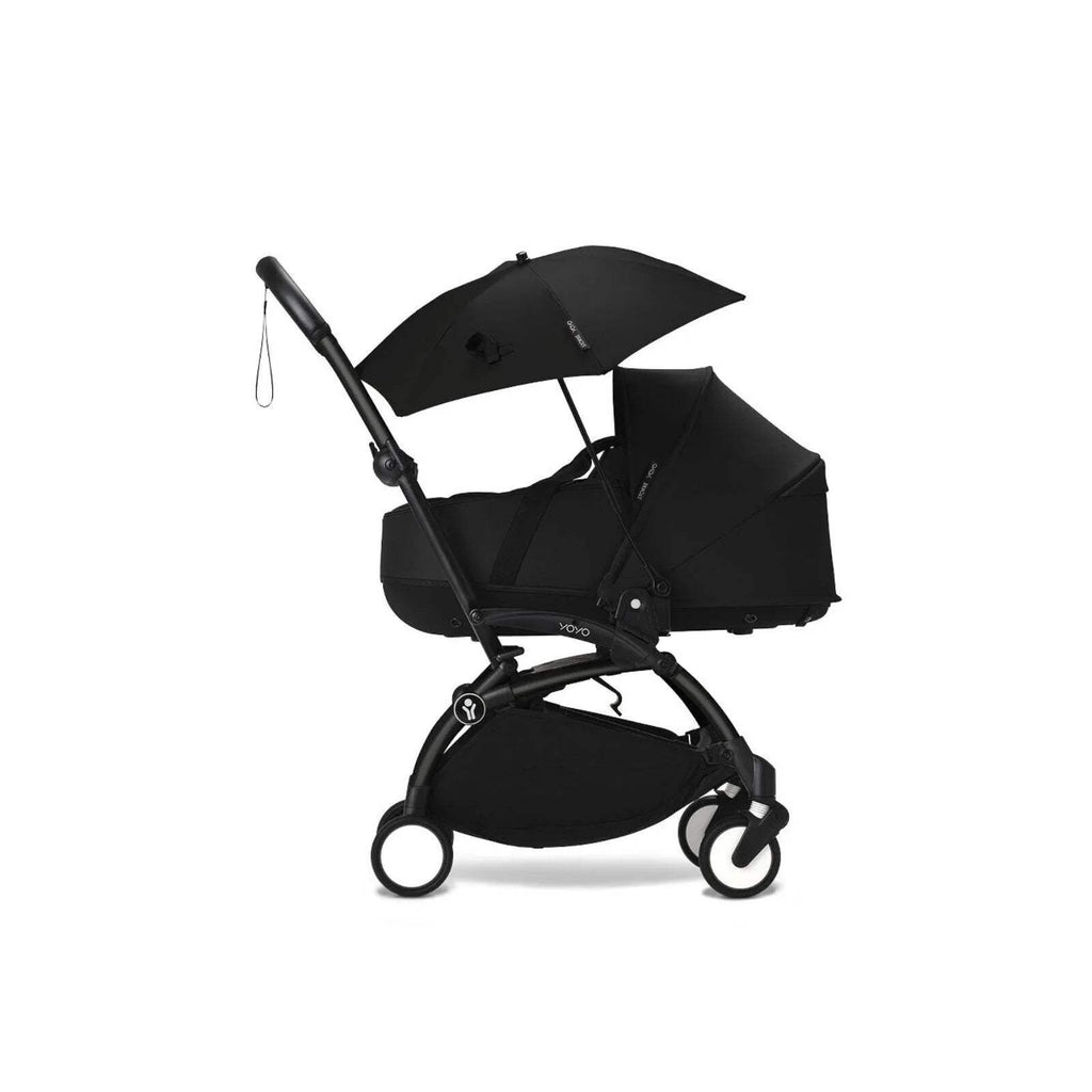 Black stroller parasol on pushchair, open canopy angled with side hanging cord