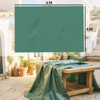 Green waterproof tarpaulin draped over outdoor furniture, with grommet corners