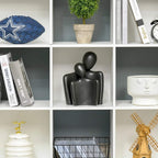 Close-up of white 9-cube storage unit with open compartments for books and decor