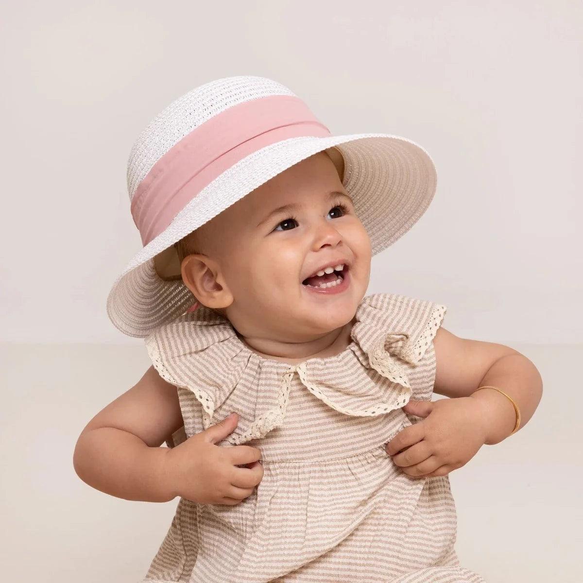 White straw baby sun hat with pink ribbon band on baby