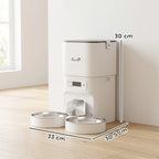 White automatic pet feeder with dual stainless steel bowls on wood floor, size labeled