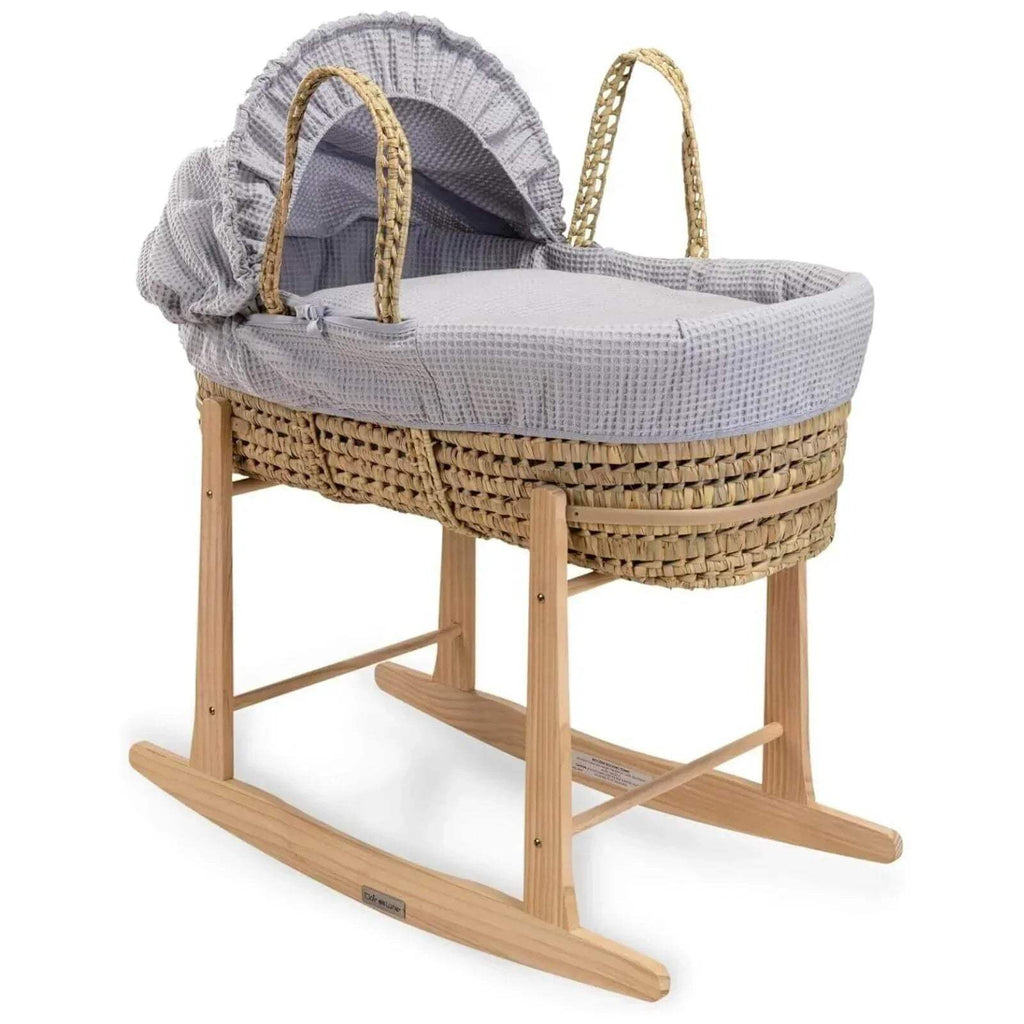 Wooden rocking stand with woven basket and gray draped cover on curved runners