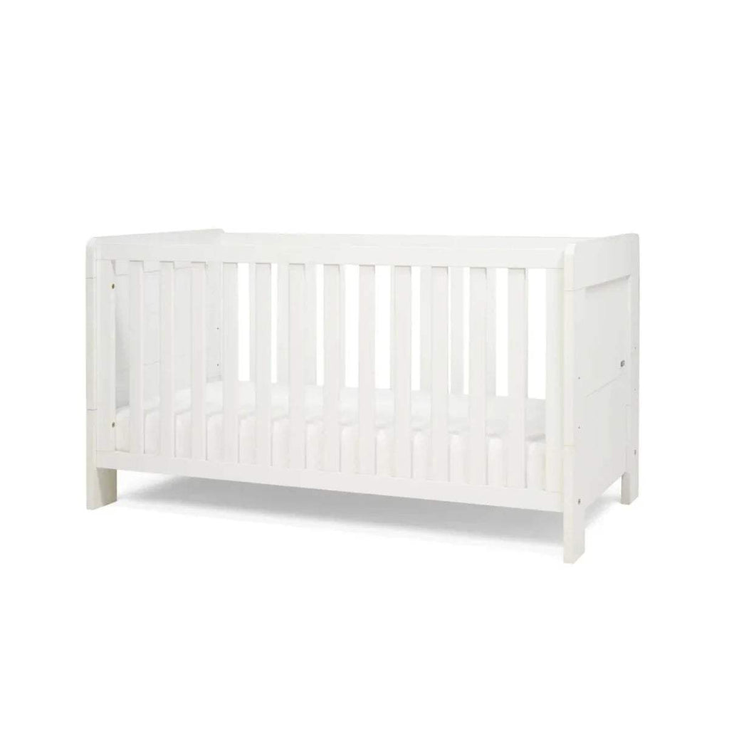 White mini cot bed side view with vertical railings and panel ends