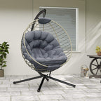 Grey hanging rattan swing chair with metal stand and tufted padded cushion