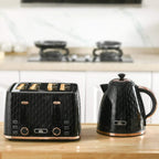Black four-slice toaster beside a black electric kettle on a kitchen countertop