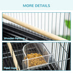 Black bird cage interior detail with light wooden perches and clear feed cup container