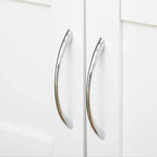 Chrome curved handles on white cabinet doors of a rolling kitchen trolley
