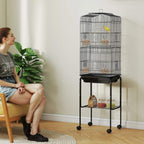 Black bird cage with front door opening, wheeled stand, and lower storage shelf