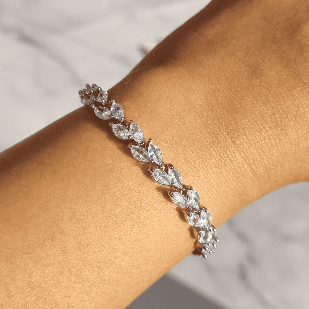 Marquise-cut petal bracelet with marquise oval stones, slender hinged links, silver tone.