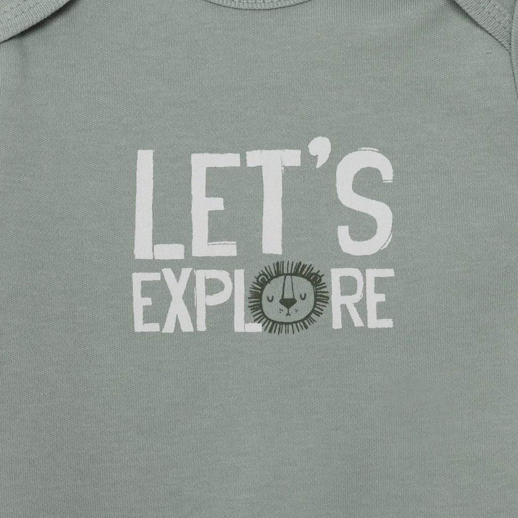 Green bodysuit close-up with “LET’S EXPLORE” lion face graphic